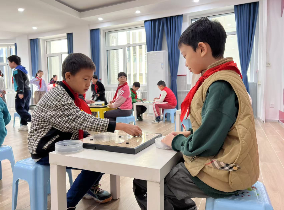 學(xué)生們?cè)谏傧汝?duì)大廳下圍棋。人民網(wǎng) 白炅攝